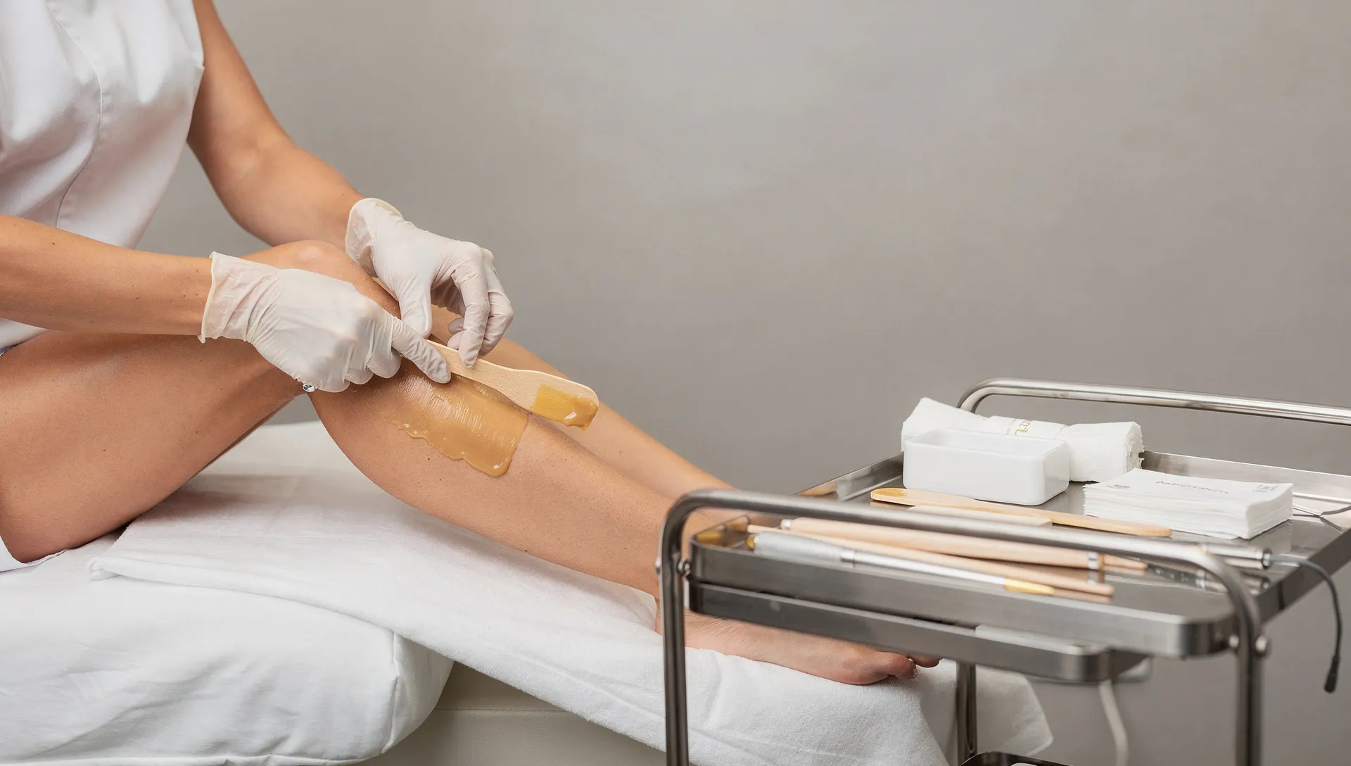 Estetista al lavoro in cabina con cera brasiliana professionale applicata con precisione